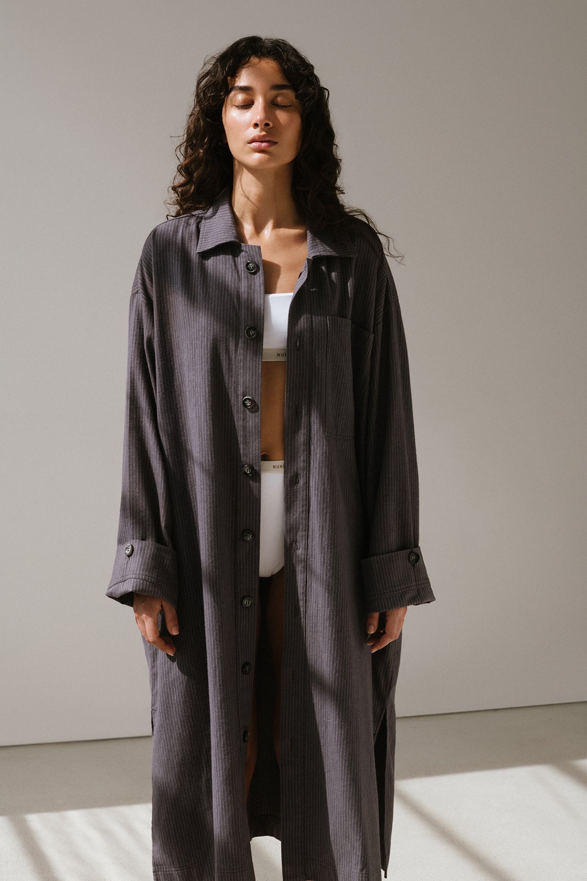 Long House Shirt in Evening Pinstripe worn over Square Neck Bralette and High Waist briefs in white by female model standing with eyes closed