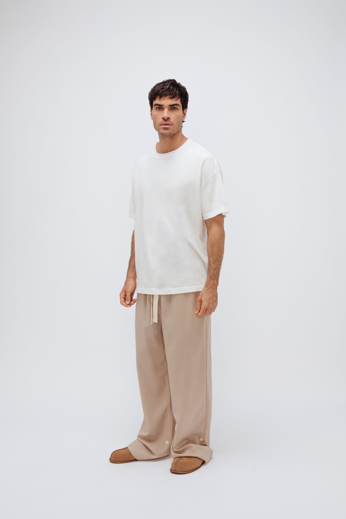 White Oversized Tee with a drop-shoulder silhouette made in organic cotton jersey and Oat Long Sleep Pant Macel worn by male model, front view