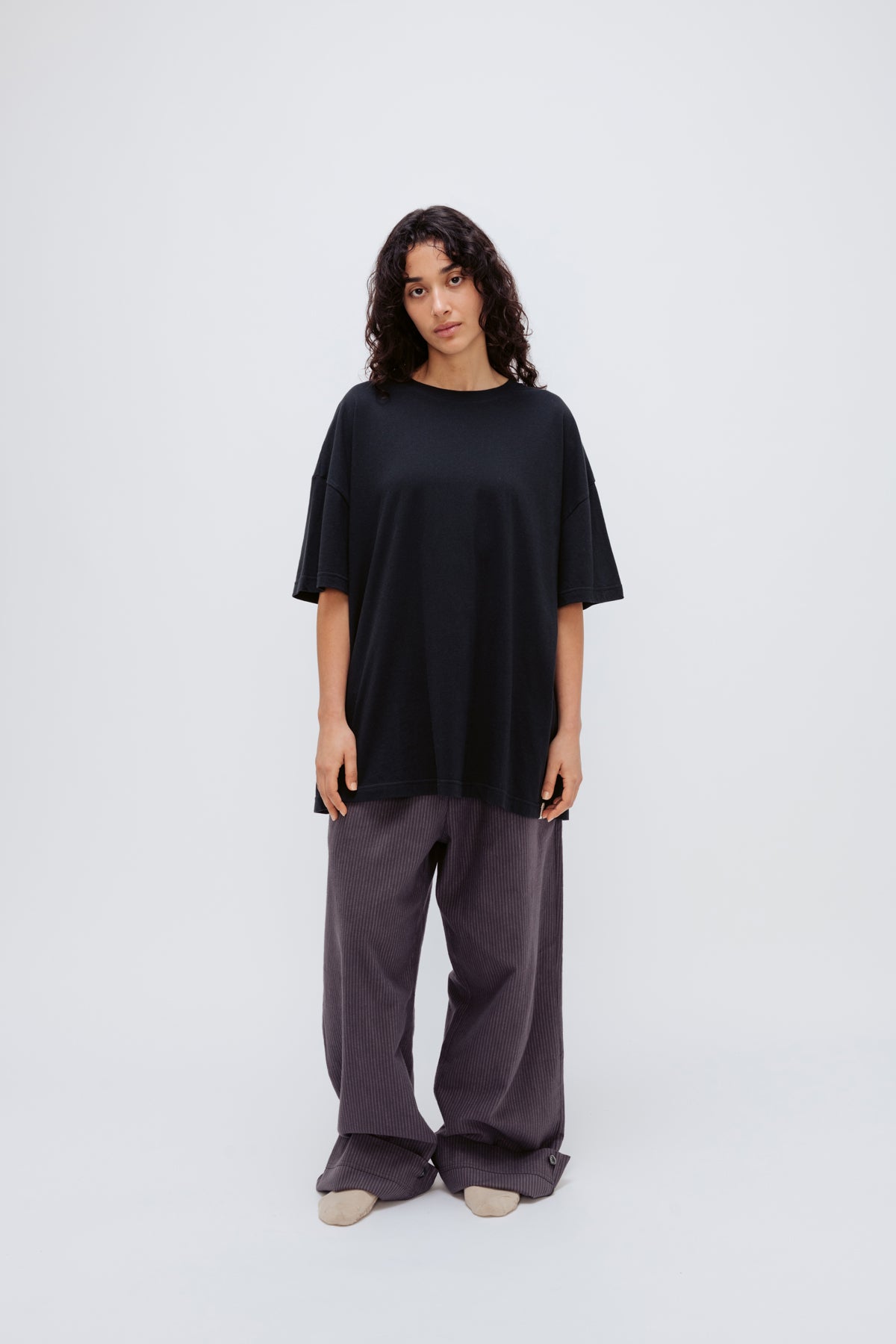 Black Oversized Tee in soft organic cotton jersey and Long Sleep Pant Flannel in Evening Pinstripe worn by female model, front view