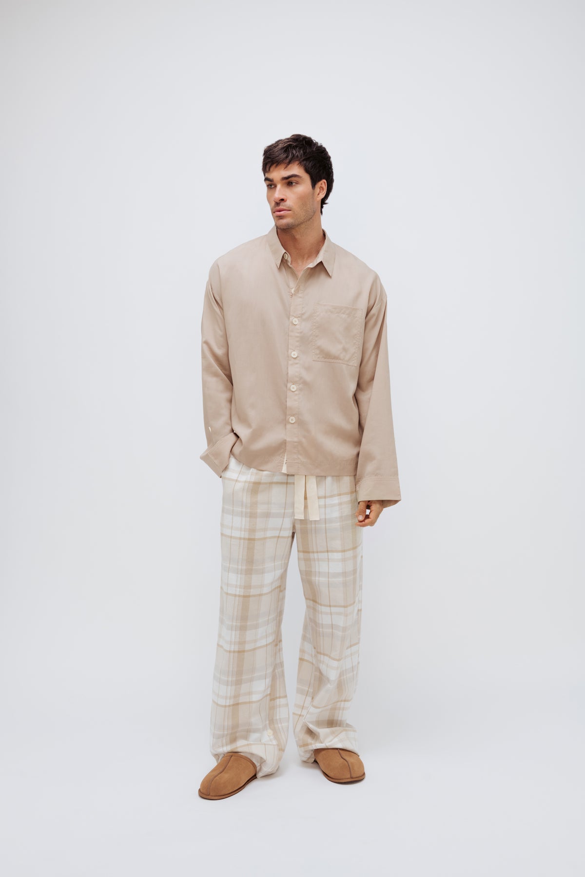 Oat long sleeve sleep shirt and flannel sleep pant in Oat Check being worn by male model, front view showing button fastenings down front of shirt and natural cotton waist tie.