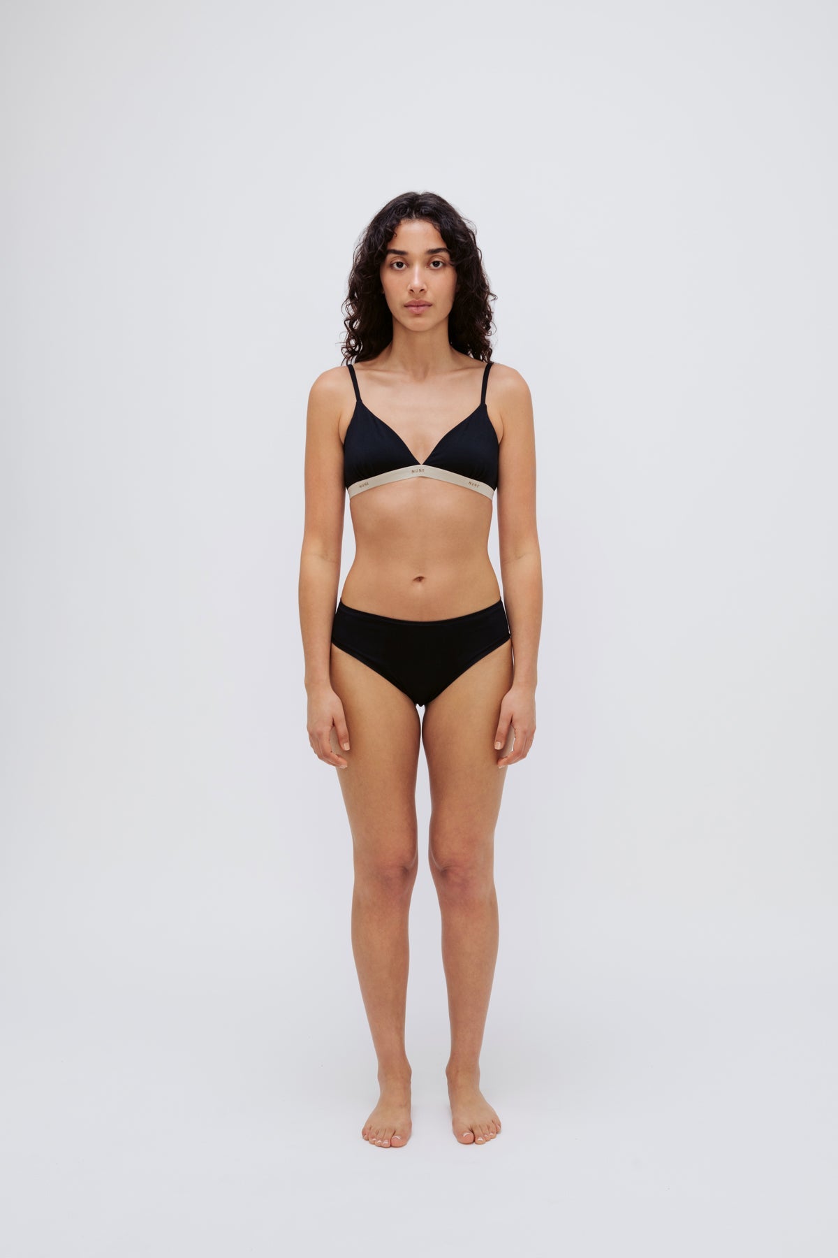 Triangle Bralette in Black and mid brief in black worn by female model, front view showing a flattering low neckline