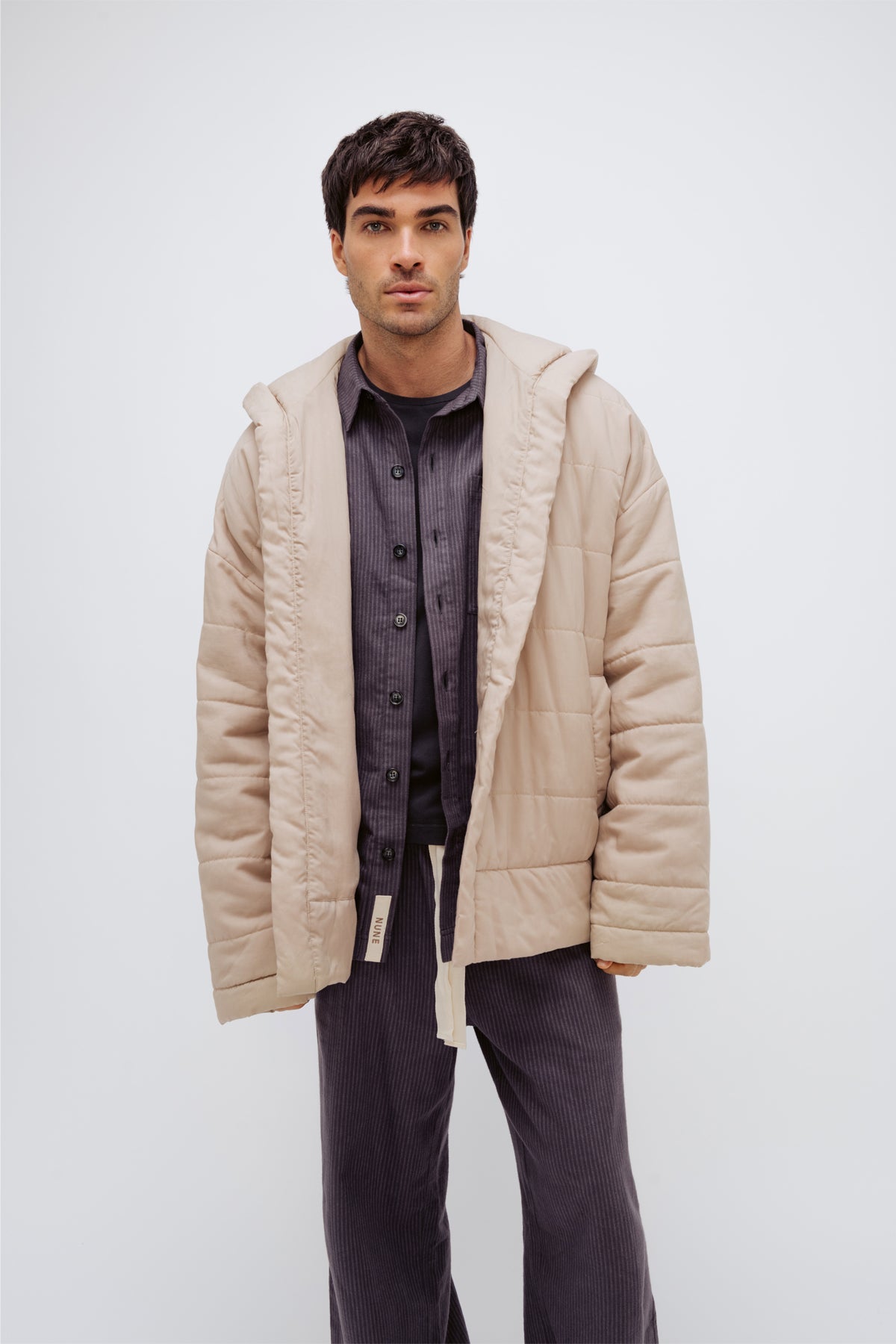Oat short robe worn over Evening Pinstripe long sleep pants and sleep shirt by male model, front view showing buttons up sleep shirt