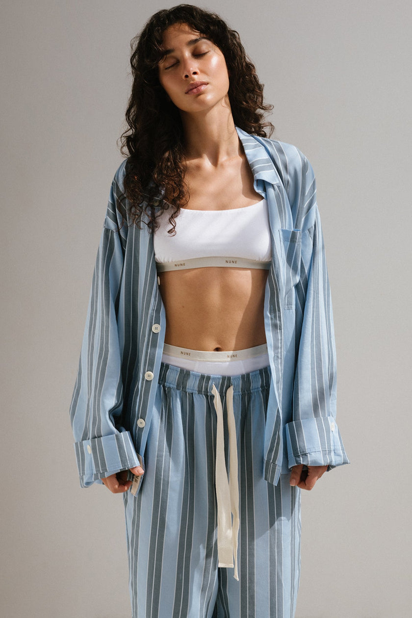 Long Sleeve Sleep Shirt and Long Sleep Pants Macel in Daybreak Stripe worn over Square Neck Bralette and High Waist Briefs in White by female model standing with her eyes closed.
