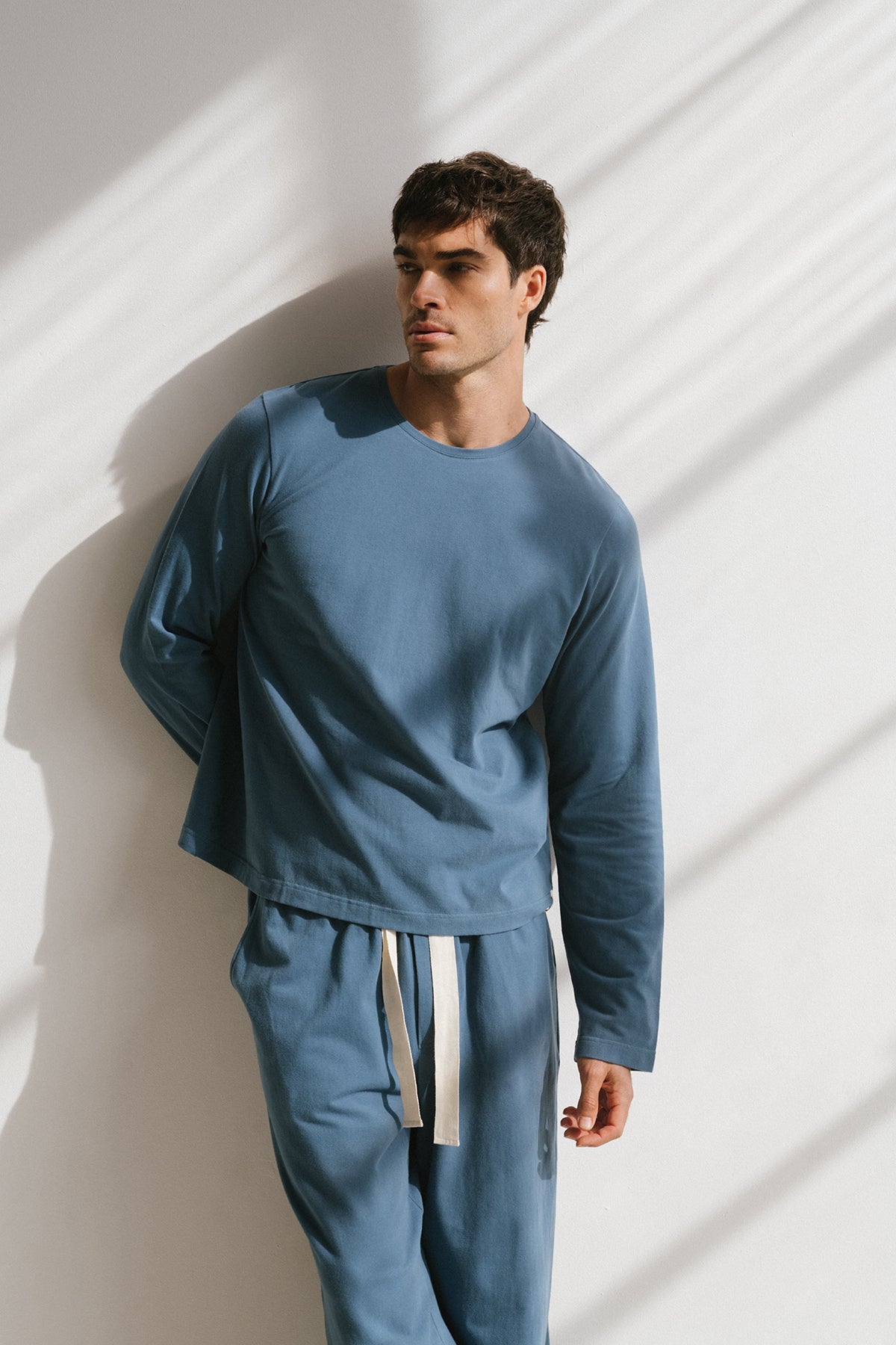 Cosy Long Sleeve Top and Cosy Pants in Noon worn by male model front view showing long sleeve length and natural cotton waist tie on pants