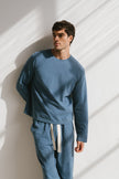 Cosy Long Sleeve Top and Cosy Pants in Noon worn by male model front view showing long sleeve length and natural cotton waist tie on pants