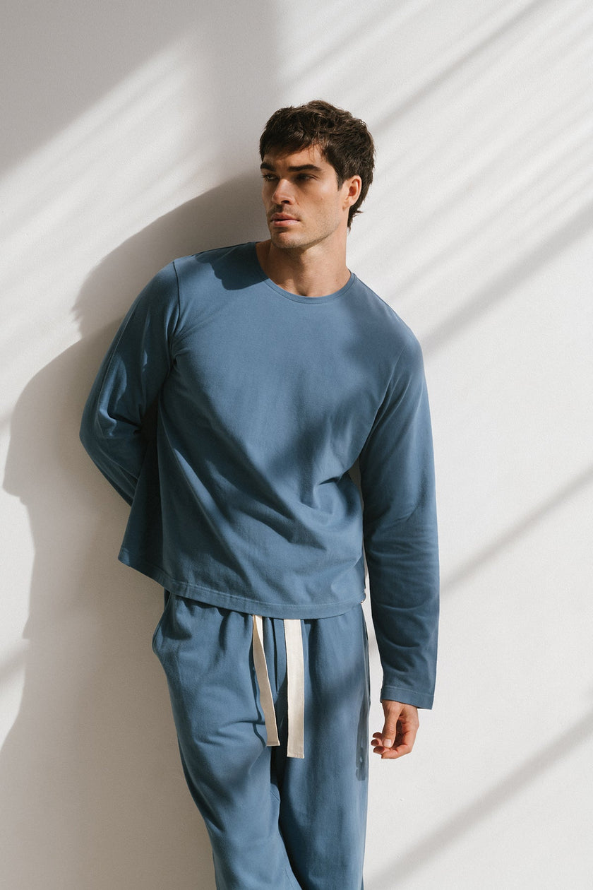 Cosy Long Sleeve Top and Cosy Pants in Noon worn by male model front view showing long sleeve length and natural cotton waist tie on pants