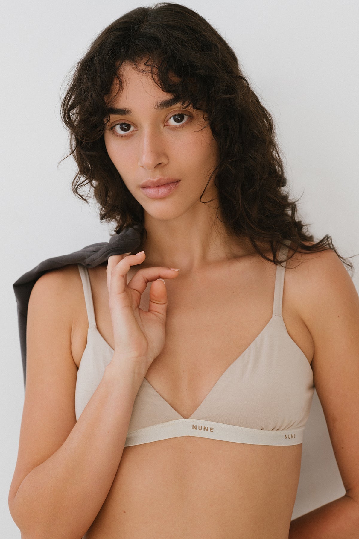 Triangle Bralette with a flattering low neckline and adjustable straps in latte silky-soft micromodal blend worn by female model with Black Oversized Tee thrown over her shoulder, front close up view
