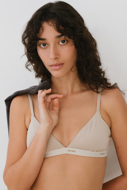 Triangle Bralette with a flattering low neckline and adjustable straps in latte silky-soft micromodal blend worn by female model with Black Oversized Tee thrown over her shoulder, front close up view