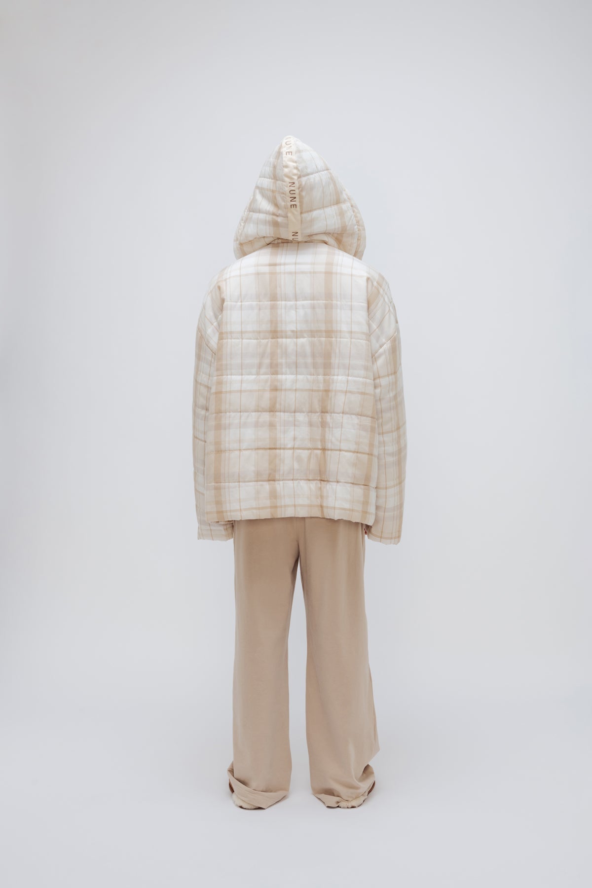 Oat Check Short Doona Robe and Cosy Pant in Oat worn by male model standing back view with hood up over his head