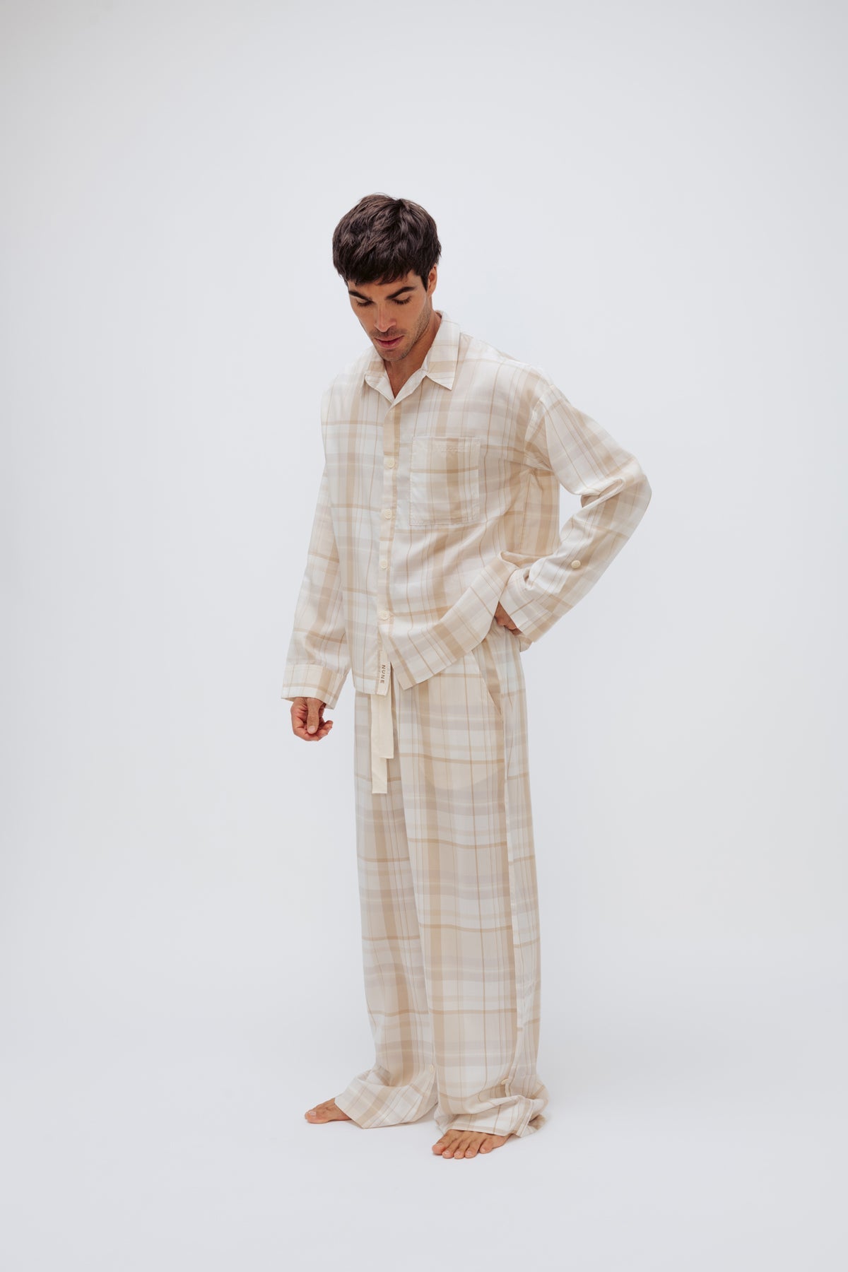 Oat Check Long Sleeve Sleep Shirt and Long Sleep Pant Macel worn by male model, front side view showing buttons and front pocket on shirt and natural cotton waist tie on pants