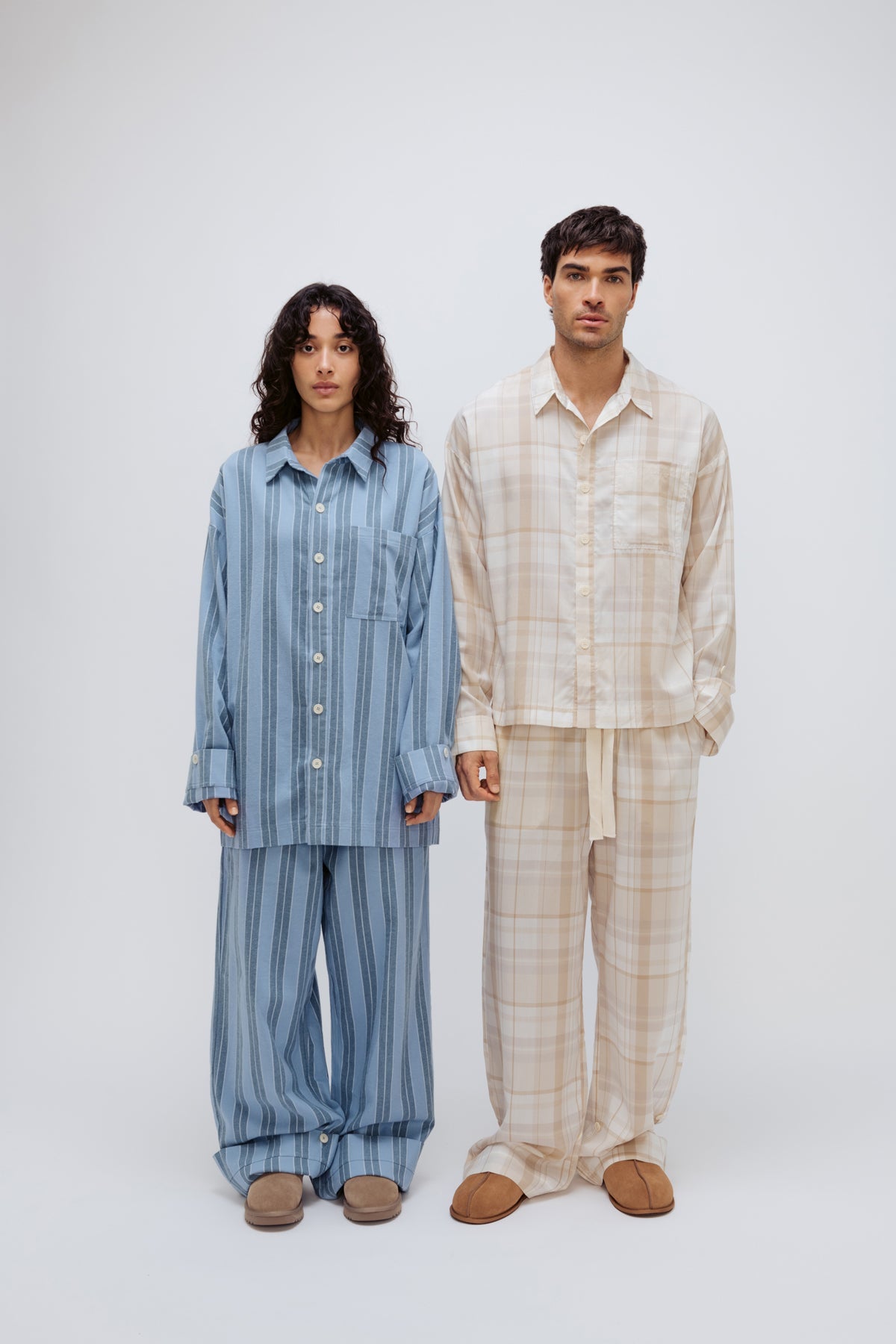 Long Sleeve Sleep Shirt and Long Sleep Pants in Daybreak Stripe Flannel worn by female model, and Long Sleeve Sleep Shirt and Long Sleep Pants in Oat Check Macel worn by male model, front view