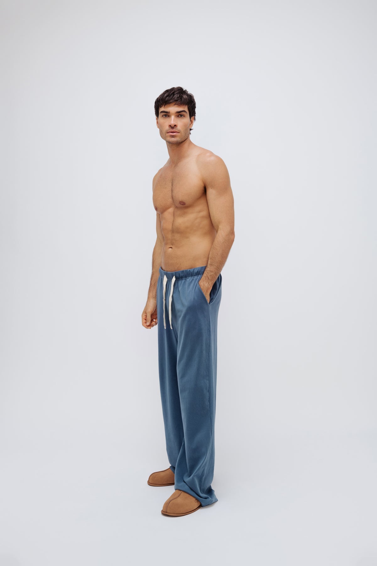 Cosy Pant in Noon worn by male model, side front view showing side pocket and natural cotton waist tie