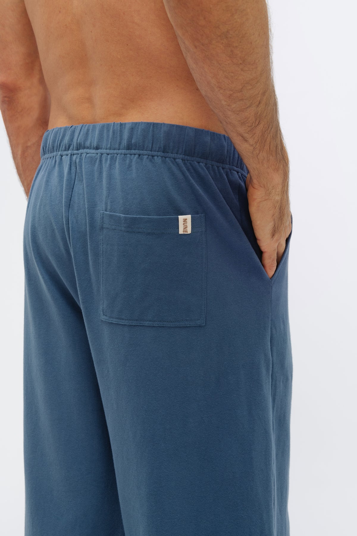 Cosy Pant in Noon worn by male model, close up view of back pocket with Nune label