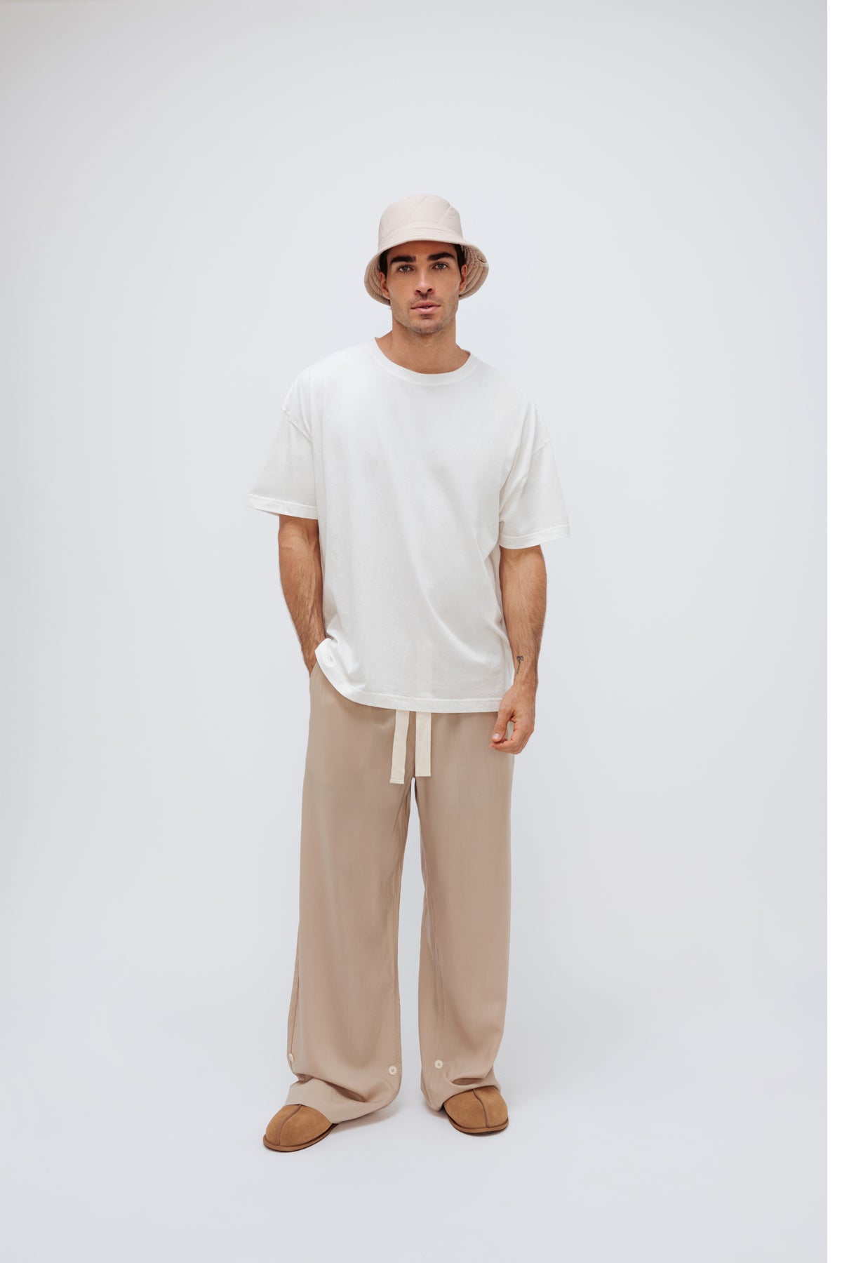 White Oversized Tee with a drop-shoulder silhouette made in organic cotton jersey, Oat Long Sleep Pant Macel and Oat Doona Hat worn by male model, front view