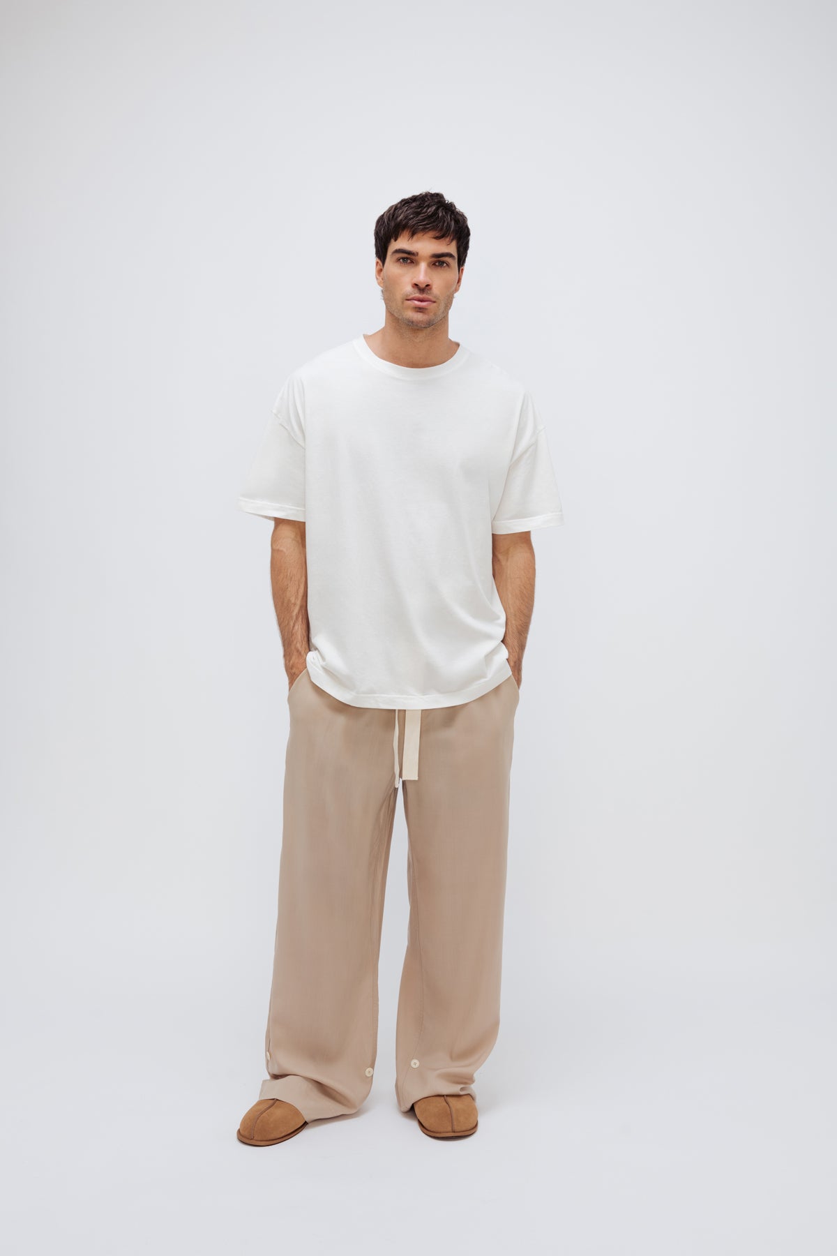 White Oversized Tee with a drop-shoulder silhouette made in organic cotton jersey and Oat Long Sleep Pant Macel worn by male model, front view