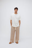 White Oversized Tee with a drop-shoulder silhouette made in organic cotton jersey and Oat Long Sleep Pant Macel worn by male model, front view