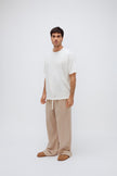 White Oversized Tee with a drop-shoulder silhouette made in organic cotton jersey and Oat Long Sleep Pant Macel worn by male model, front view