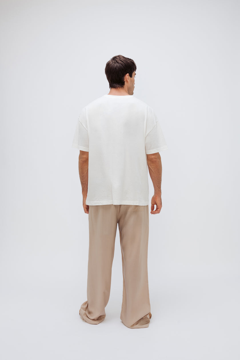 White Oversized Tee with a drop-shoulder silhouette made in organic cotton jersey and Oat Long Sleep Pant Macel worn by male model, back view