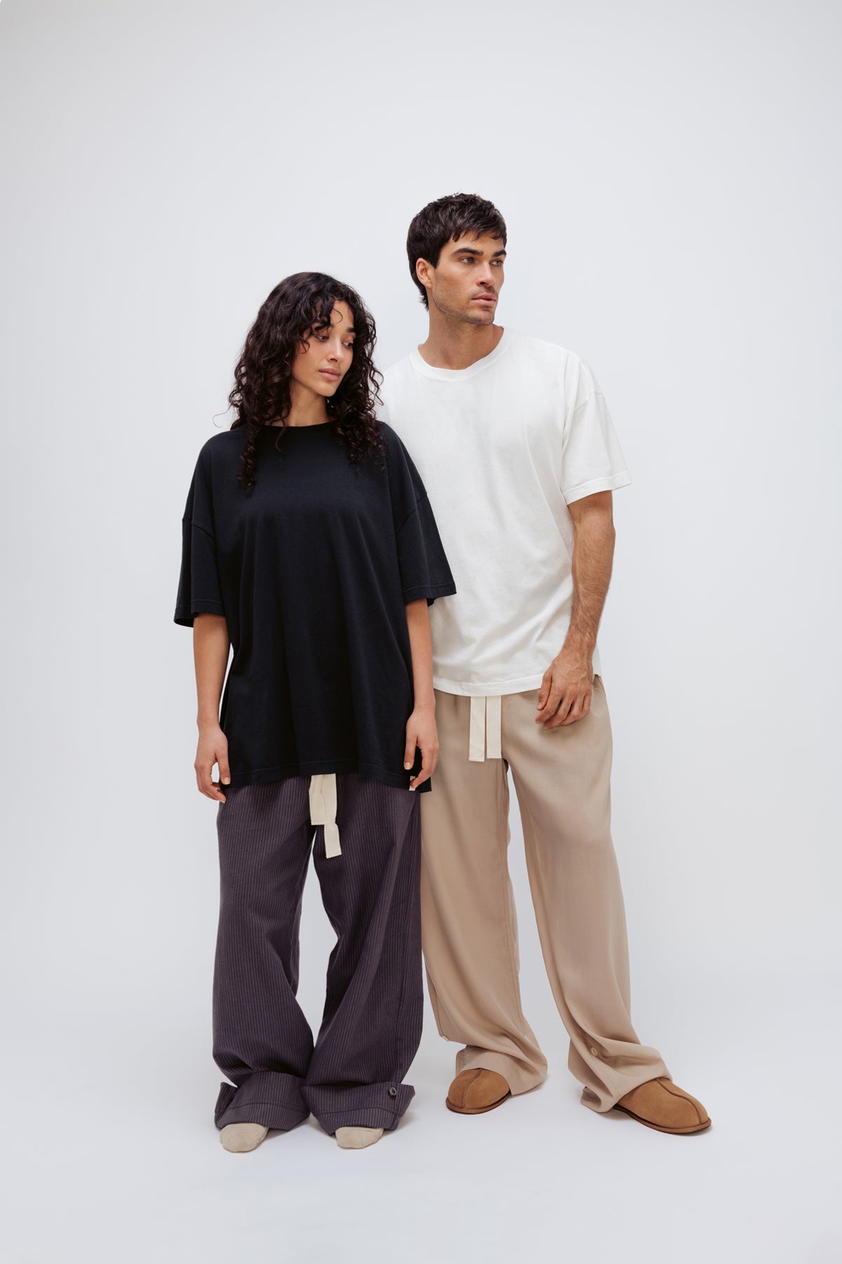 Black Oversized Tee and Long Sleep Pant Flannel in Evening Pinstripe worn by female model and White Oversized Tee with Oat Long Sleep Pant Flannel worn by male model, front view