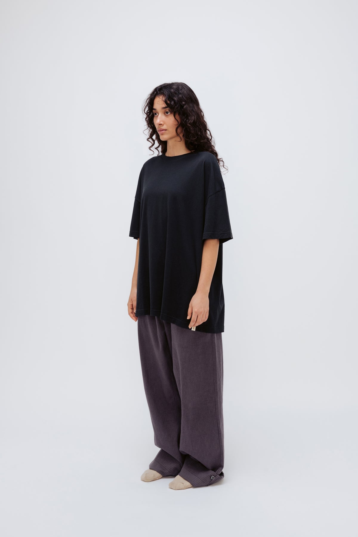 Black Oversized Tee in soft organic cotton jersey and Long Sleep Pant Flannel in Evening Pinstripe worn by female model, front side view