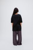 Black Oversized Tee in soft organic cotton jersey and Long Sleep Pant Flannel in Evening Pinstripe worn by female model, back view