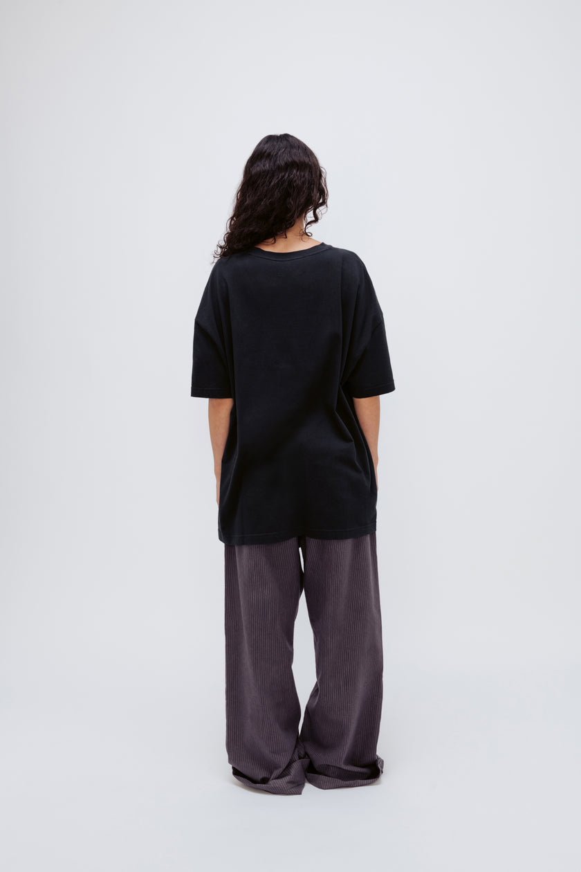 Black Oversized Tee in soft organic cotton jersey and Long Sleep Pant Flannel in Evening Pinstripe worn by female model, back view