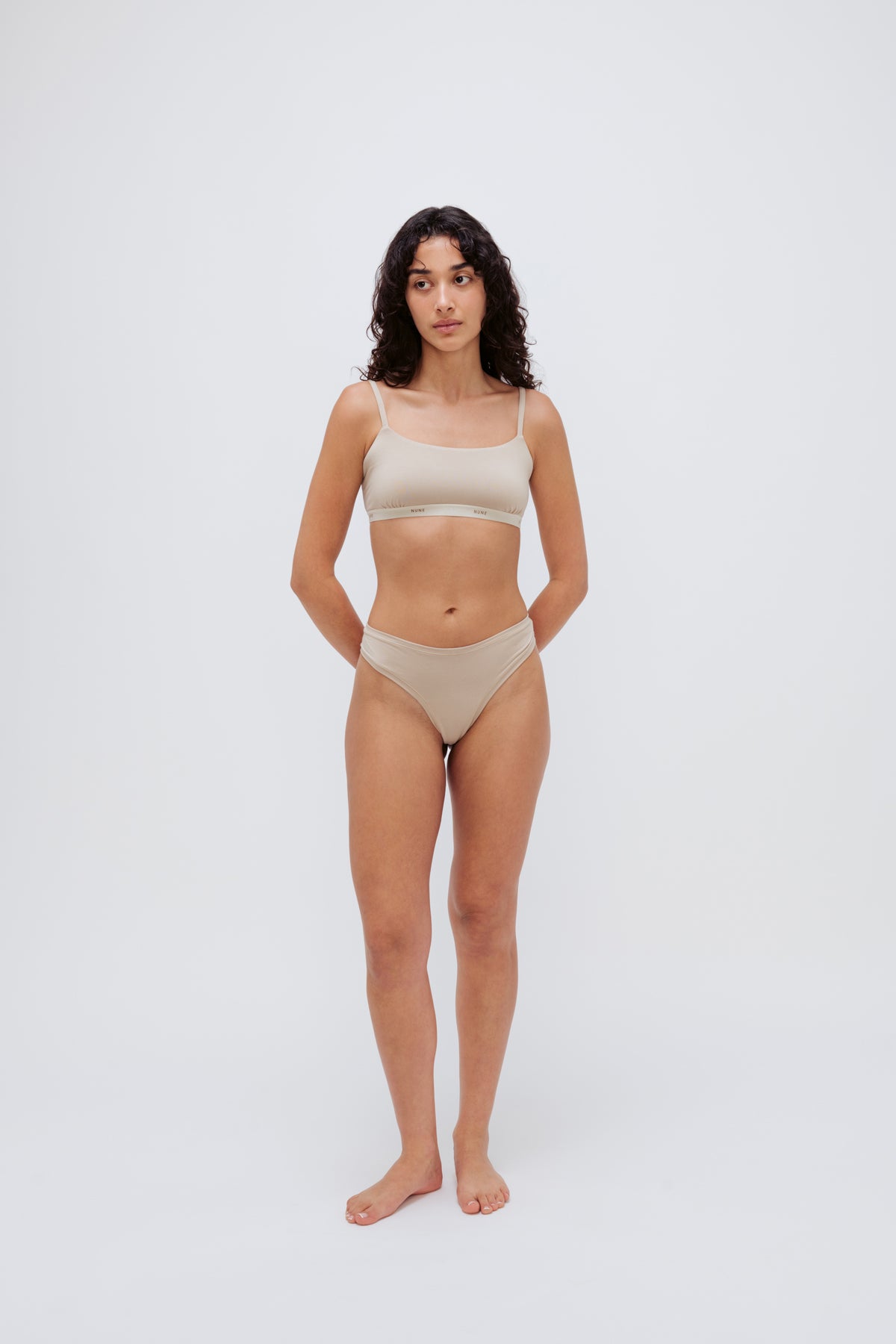 Square Neck Bralette in latte silky-soft micromodal blend worn with women's latte g string by female model, front view showing softly structured silhouette and NUNE soft elastic on bralette.