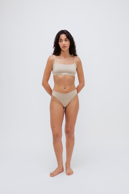 Square Neck Bralette in latte silky-soft micromodal blend worn with women's latte g string by female model, front view showing softly structured silhouette and NUNE soft elastic on bralette.