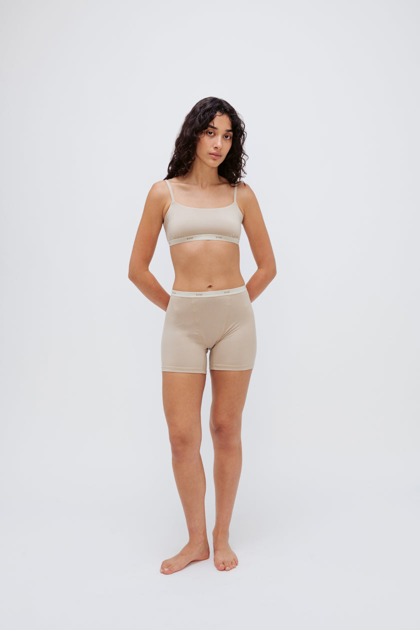 Women’s Boxer Brief in Latte silky-soft micromodal blend, like his Boxer Briefs, only cooler, and Square Neck Bralette in Latte worn by female model, front view