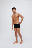 Men's black original briefs worn by model front view looking off to side with hand on hip