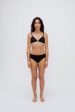 Triangle Bralette in Black and mid brief in black worn by female model, front view showing a flattering low neckline