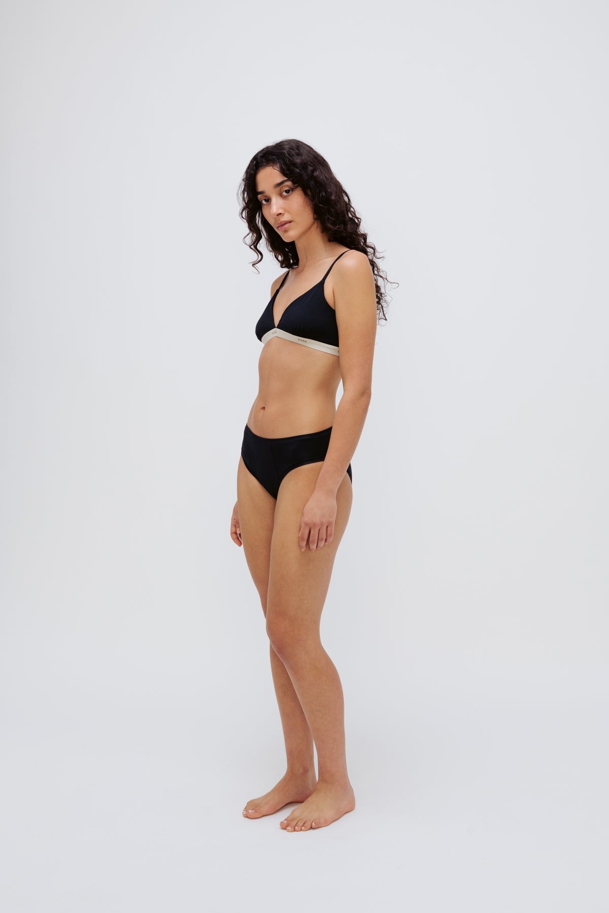 Triangle Bralette in Black and mid brief in black worn by female model, front side view