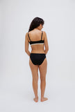 Triangle Bralette in Black and mid brief in black worn by female model, back view showing adjustable straps on bralette