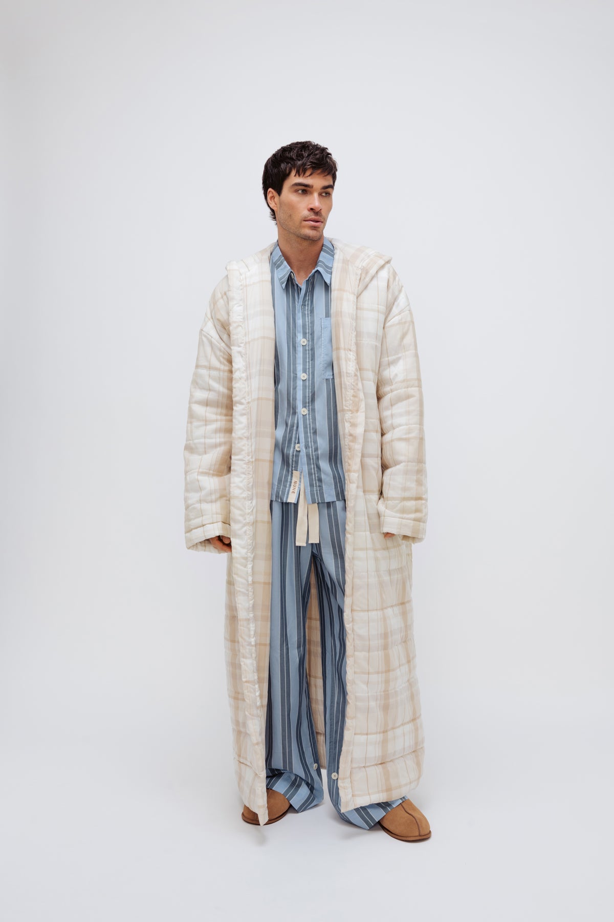 Long Doona Robe in Oat Check layered over Long Sleeve Sleep Shirt and Long Sleep Pants Macel in Daybreak stripe by male model, front view