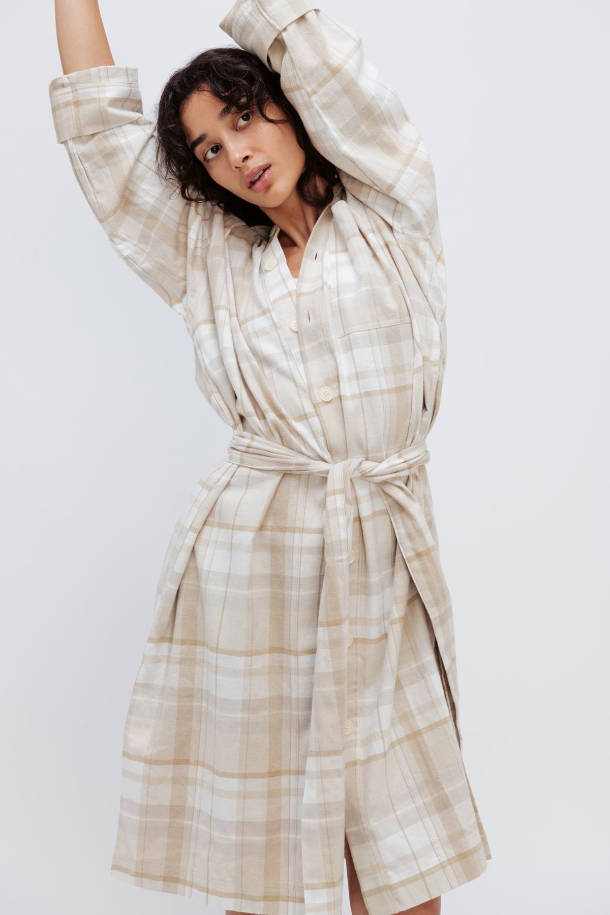 Oat Check House Shirt worn by female model, cropped front view showing the removable waist tie with model's arms stretched above her head