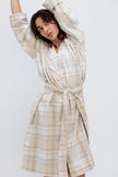 Oat Check House Shirt worn by female model, cropped front view showing the removable waist tie with model's arms stretched above her head