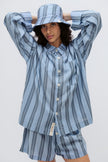 Long Sleeve Sleep Shirt Macel, Boxer Short and Doona Hat all in Daybreak Stripe worn by female model holding her hands behind her head, cropped front view.