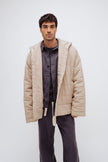 Oat short robe worn over Evening Pinstripe long sleep pants and sleep shirt by male model, front view showing buttons up sleep shirt