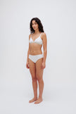 White triangle bralette and white mid brief worn by female model, front side view showing flattering low neckline on bralette and double-lined front on briefs.