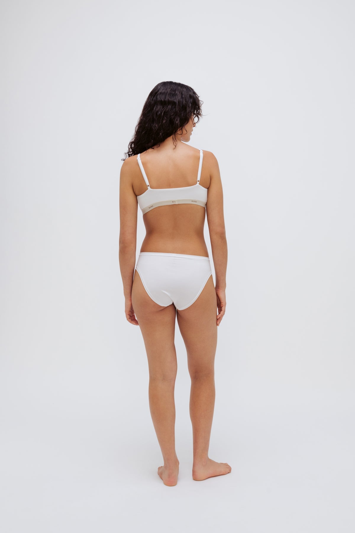 White triangle bralette and white mid brief worn by female model, back view showing adjustable straps on bralette