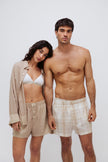 Oat boxer shorts and sleep shirt worn by female model over white triangle bralette and oat check boxer shorts worn by male model both facing front