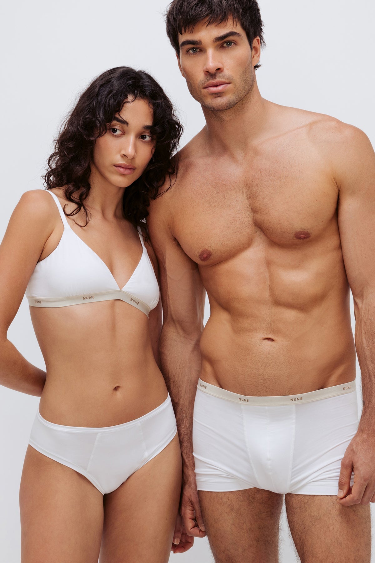 Women’s Mid Brief in White silky-soft micromodal blend worn with White Triangle Bralette worn by female model and White Original Boxer Briefs worn by male model, cropped front view