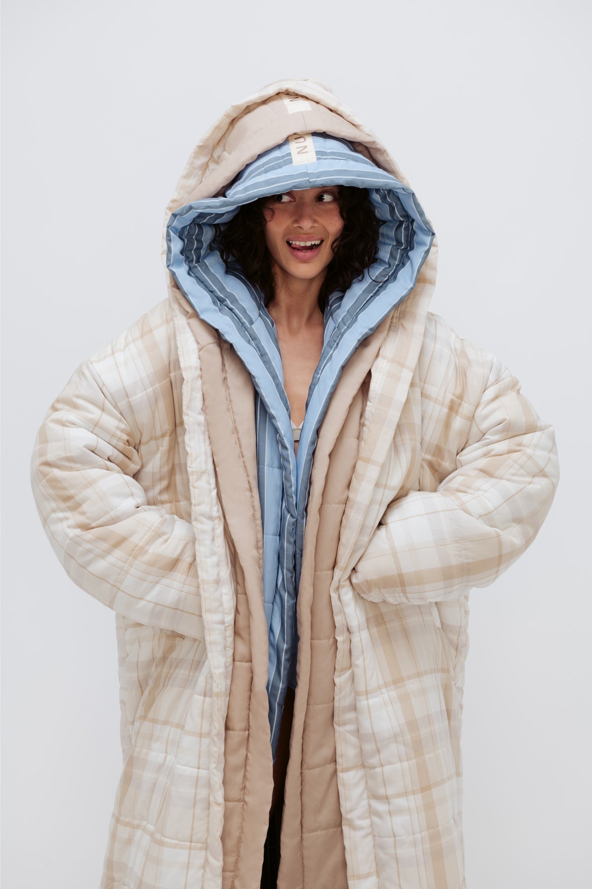 Long Doona Robes in Daybreak Stripe, Oat and Oat Check worn layered by female model smiling with all 3 robe hoods over her head
