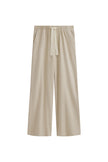 The Cosy Pant in Latte offers a refined alternative to traditional track pants. Front view showing front pockets and natural cotton waist tie.