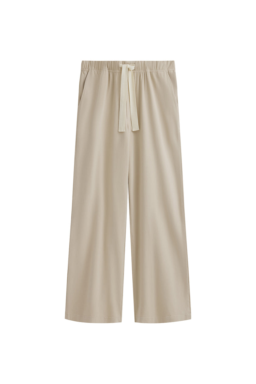 The Cosy Pant in Latte offers a refined alternative to traditional track pants. Front view showing front pockets and natural cotton waist tie.