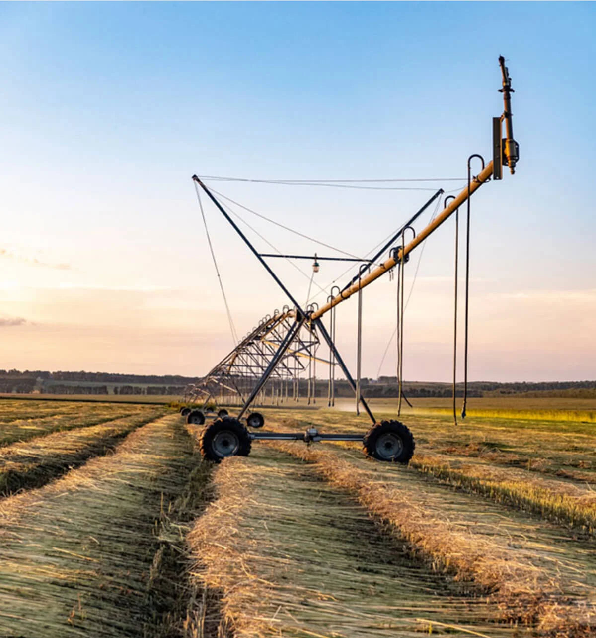 Large agricultural irrigation system in a field with a clear sky.