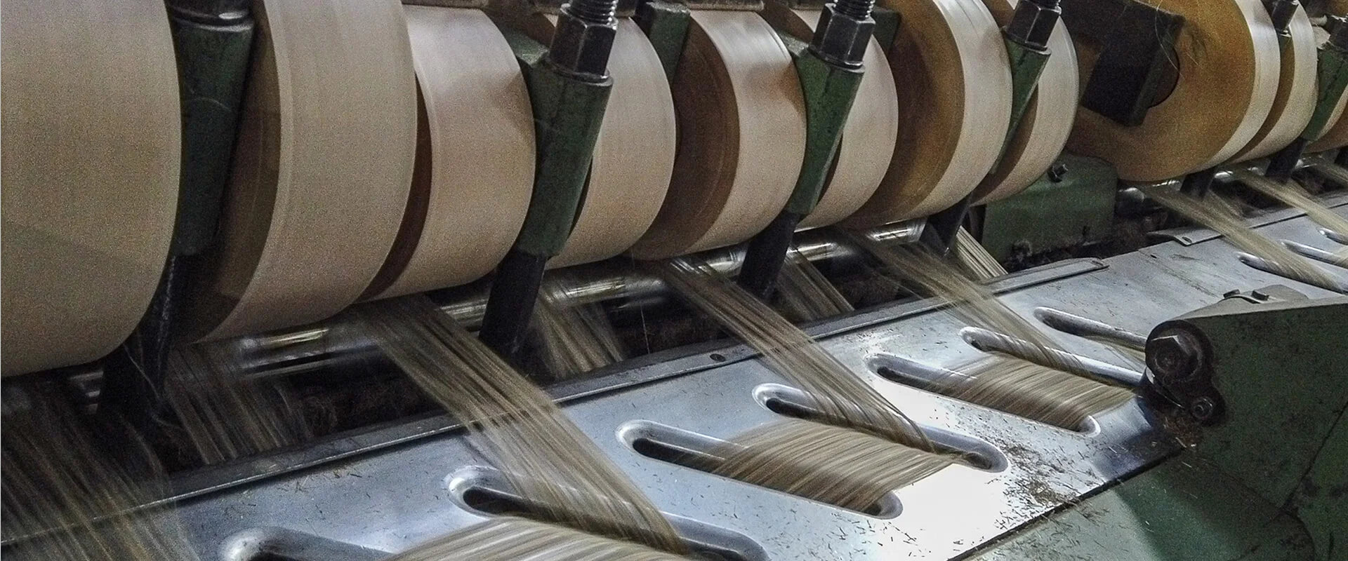 Close up of reels of fibres being wound in a factory